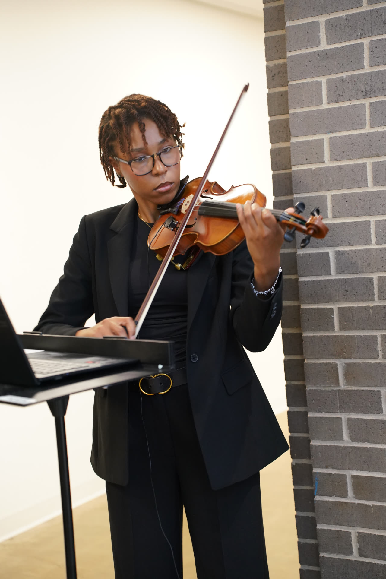 A musician in formal black clothing playing the violin