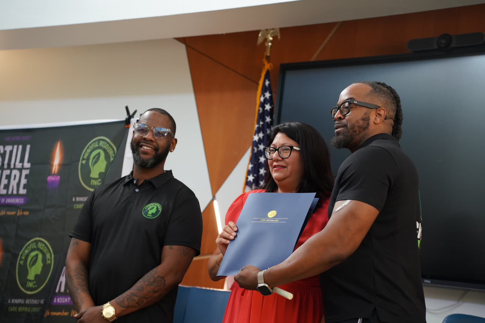 A City of Dallas proclamation held in front of the Still Here backdrop